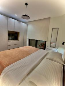 Charming and Bright Tirana Center Apartament في تيرانا: غرفة نوم مع سرير أبيض كبير في غرفة