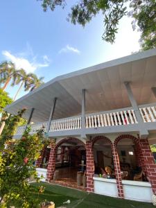 a house with a white roof and a brick at LA CASONA SV Hostal in La Libertad