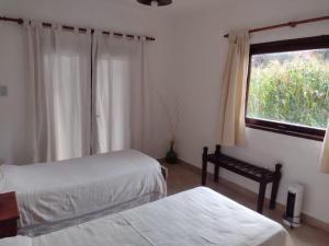 een slaapkamer met 2 bedden en een raam bij Luna Jatun in Purmamarca