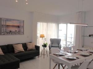 sala de estar con sofá, mesa y sillas en Marina Apartment (junto al mar), en Blanes