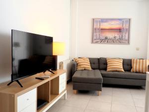 sala de estar con sofá y TV de pantalla plana en Marina Apartment (junto al mar), en Blanes