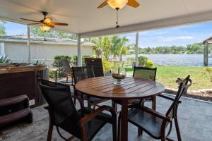 a table and chairs on a patio with a view of the water at Riverfront Oasis Stunning Inside and Out Remodeled 3BR Riverfront Home with Hot Tub and personal paddle boats with Access to the Gulf in Riverview