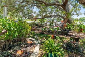 Um jardim no exterior de Riverfront Oasis Stunning Inside and Out Remodeled 3BR Riverfront Home with Hot Tub and personal paddle boats with Access to the Gulf