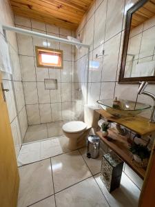 a bathroom with a shower and a toilet and a sink at Pousada Recanto da Gruta in Urubici