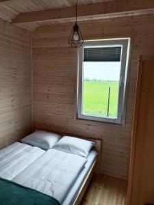 A bed or beds in a room at R&R Mielno Domki Letniskowe