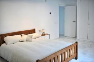 - une chambre dotée d'un grand lit avec des draps et des oreillers blancs dans l'établissement Bright apartment in the hills of Elviria, à Malaga