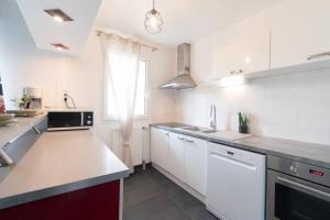 a kitchen with white cabinets and a counter top at Le Douillet-T2-55m2-10min Disney in Bussy-Saint-Georges