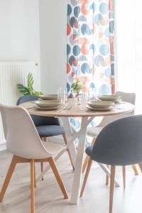 a dining room table and chairs with a white table and chairs at Le Douillet-T2-55m2-10min Disney in Bussy-Saint-Georges