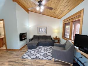 a living room with a couch and a flat screen tv at Cabin A Suite Bed and Breakfast in Woodland Park