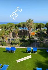 a group of blue chairs sitting on the grass at Dedelollo’s Home in Sanremo