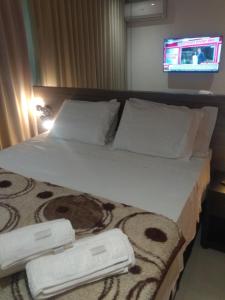 a hotel room with a bed with two towels on it at Flat Grand Midas- Rio Centro- Rock in Rio- Farmasi Arena- Projac- Barra- Parque Olimpico in Rio de Janeiro +15 photos