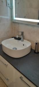 lavabo blanco en el baño con espejo en Maison de village type 2 en Sainte-Croix-de-Verdon