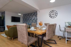 a dining room with a wooden table and chairs at Heartland House, 7 Spacious Bedrooms Sleeps 4 plus, near NEC, JLR,BHX in Birmingham