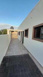 un couloir d'un bâtiment blanc avec garage dans l'établissement Departamento 3 personas, à Las Heras