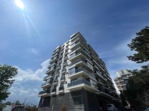 een hoog appartementencomplex met de zon in de lucht bij LUXURY Residence Apartments in Mamaia