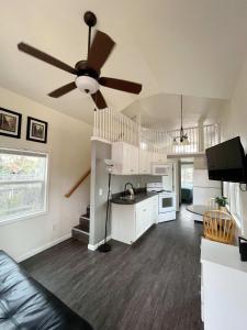 ein Wohnzimmer mit einem Deckenventilator und eine Küche in der Unterkunft Cedar Tiny Home in Woodland Park