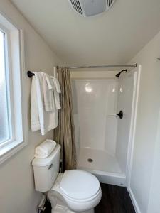 ein Badezimmer mit einem weißen WC und einer Dusche in der Unterkunft Cedar Tiny Home in Woodland Park