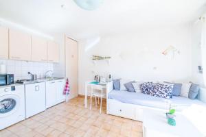 een woonkamer met een bank en een keuken bij EMbnb - Studio Near Geneva in Étrembières