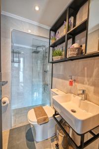 Un baño con lavabo, inodoro y ducha. en Haroto Home Residence, en Plokamianá