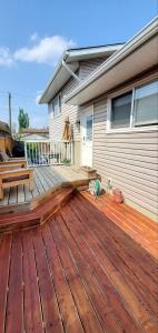 eine Holzterrasse vor einem Haus in der Unterkunft Private Studio Apartment House in Calgary