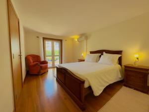 een slaapkamer met een groot bed en een stoel bij Casino Villa with Sea View in Funchal