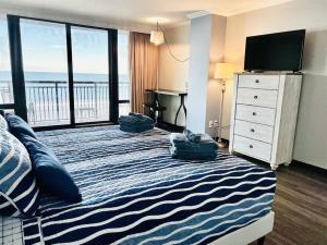 um quarto com uma cama grande com almofadas em *OCEANFRONT SUNNY FUN*Queen Beds *Great Pools, Hot Tubs+*M44 em Myrtle Beach