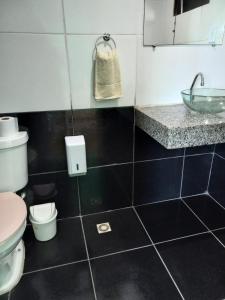 a bathroom with a toilet and a sink at Varandas Lagoa Azul in Araruama