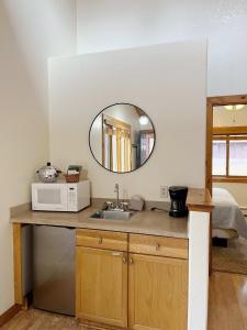 a kitchen with a sink and a mirror at Cabin Suite in Woodland Park