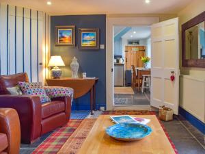 a living room with a couch and a table at Puffin Cottage in Abereiddy