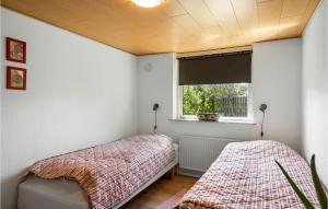 Un dormitorio con dos camas y una ventana. en Awesome Home In Thyborøn With Wifi, en Thyborøn