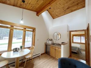 a room with a table and chairs and a bed at Cabin suite bed and breakfast in Woodland Park