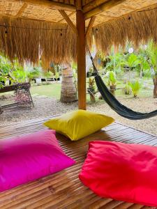 - 2 oreillers roses et jaunes sur une terrasse en bois avec hamac dans l'établissement Bohol Island Homestay, à Dauis