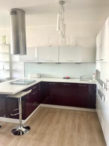 a white kitchen with a sink and a counter at Modern apt, parking in garage and walk to town in Bratislava
