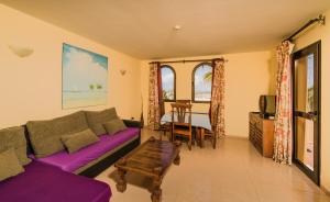 een woonkamer met een paarse bank en een tafel bij Oasis vistamar in Corralejo