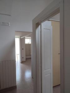 una habitación vacía con una puerta blanca y un pasillo en Casa Uccio spaziosa, nell'entroterra salentino, vicina a diverse spiagge, en Botrugno
