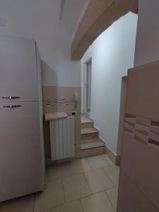 una cocina con nevera blanca y una escalera en Casa Uccio spaziosa, nell'entroterra salentino, vicina a diverse spiagge, en Botrugno