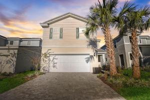 a house with a garage and two palm trees at luxury new 5 bedroom solterra resort close to disney in Davenport