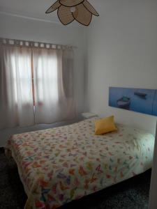 a bedroom with a bed with a yellow pillow on it at Casa Caleta Caballo in Caleta de Caballo