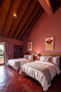 - 2 lits dans une chambre aux murs rouges dans l'établissement HOLT Balcones Guesthouse - Two Double Beds Room, à San Miguel de Allende