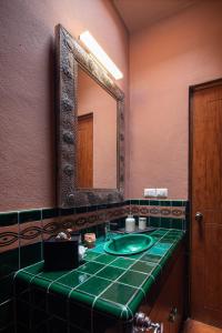 HOLT Balcones Guesthouse - Two Double Beds Room في سان ميغيل دي الليندي: حمام مع حوض أخضر ومرآة