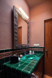 une salle de bain avec un lavabo vert et un miroir dans l'établissement HOLT Balcones Guesthouse - Two Double Beds Room, à San Miguel de Allende 62 autres photos