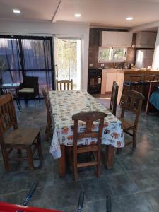 comedor con mesa y sillas y cocina en MAIPU Apart en Maipú