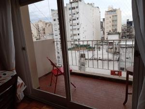 Habitación con ventana y balcón con silla. en Lo de Susi en Buenos Aires