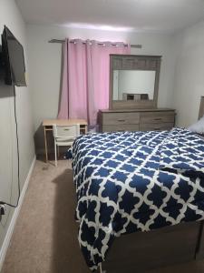 a bedroom with a bed and a dresser and a mirror at Prestige Guest Room London Ontario in London