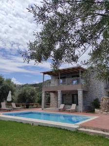 a house with a swimming pool in front of it at Iris Villas Complex in Lefkada Town