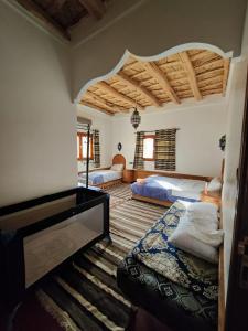 een slaapkamer met 2 bedden en een groot plafond bij Auberge NICE VIEW DADES in Akhendachou nʼAït Ouffi
