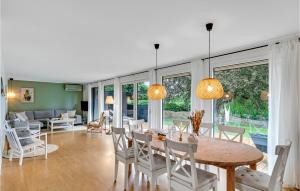 a dining room and living room with a table and chairs at 3 Bedroom Awesome Home In Vejby in Vejby