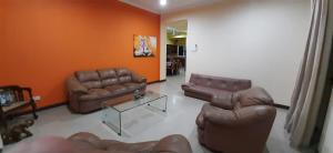 a living room with two leather couches and a table at Rudra Residence Apartment in Colombo