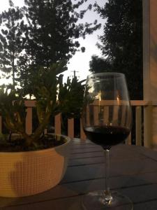 un verre de vin rouge assis sur une table dans l'établissement Drift-Inn Cottage, self contained country escape., à Kandanga