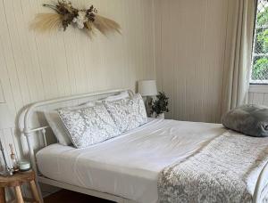 - une chambre avec un lit blanc et une fenêtre dans l'établissement Drift-Inn Cottage, self contained country escape., à Kandanga